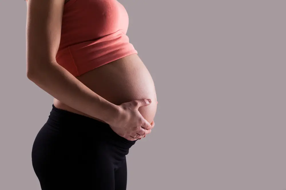 A pregnant women placing hands on belly