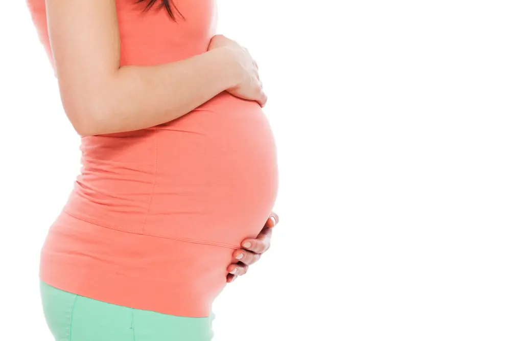 A pregnant women placing hands on belly