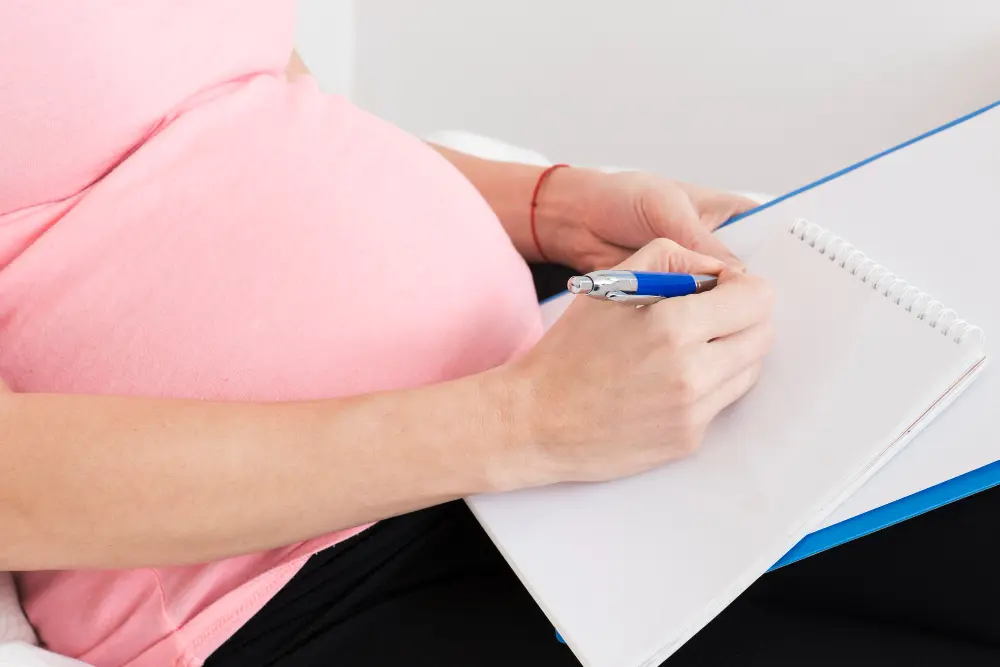 Pregnant women writing on pad