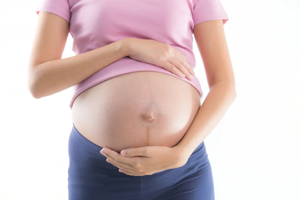 A pregnant women placing hands on belly